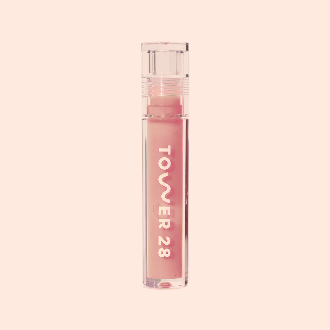 Photo of ShineOn Milky Lip Jelly in a slim acrylic tube with large "Tower 28" logo in shade Oat (a milky peachy-pink shade)
